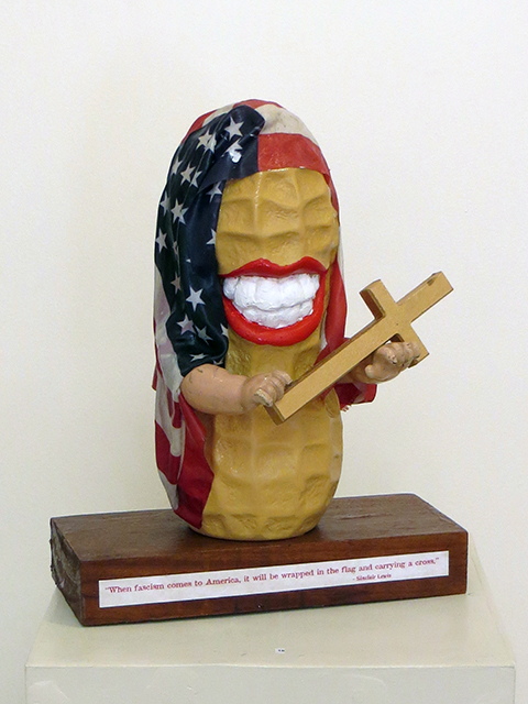 Kathleen McSherry  “Amerika” found objects, plastic bank, doll arms, lowercase letter, flag, woodbase $550.00