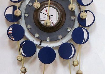 Randall Cleaver -“Moon Days Times 2” cookie tins, bike rim, metal plate, grill pan, plastic balls, “L” brackets, brass plumbing part, new pendulum and clock movements