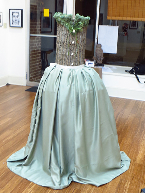 Lora Hudicka  – “One Whimsical Dance” sculpture – hollowed tree trunk, silk ribbon, dried moss, flowers, fabric