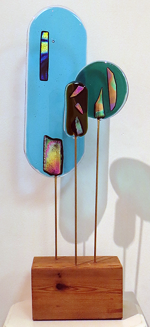 “Three for One”   fused glass, brass rods and wood, by Ellen Rebarber