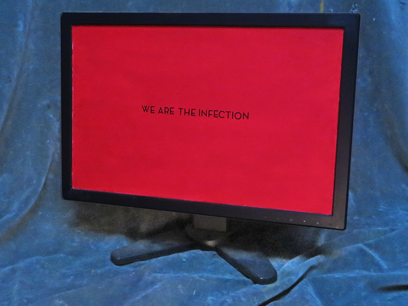 “We Are The Infection” – repurposed computer monitor, day glow paint stick on letters – 18″ x 16″ x 6″