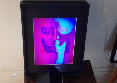 Larry McCandlish “Unmasked II (with mask)” digital image print, ink dye on luster paper w/dynamic back illumination 11.5”W x 14.5”H x 2.25” D, 2023, $600.00