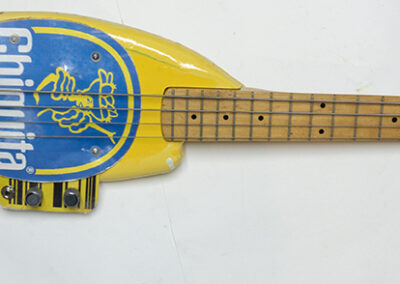 Banana Bass – cut and shaped wood, electric bass guitar parts, plexiglass, paint – $800.00